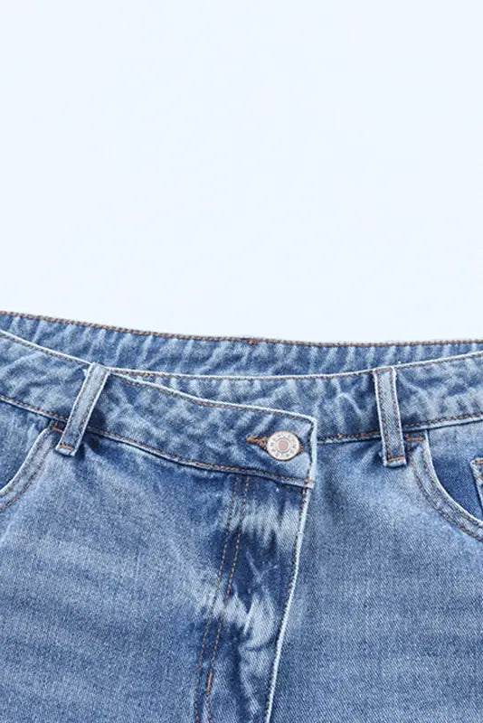 Crossover waist denim shorts showcasing waistband and top portion of blue denim jeans