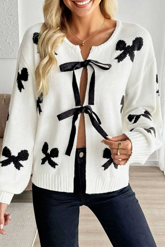 White Bow‑Lace Knit Cardigan with black bow details, soft knit texture, and front ribbon ties, styled for spring layering in women's fashion.