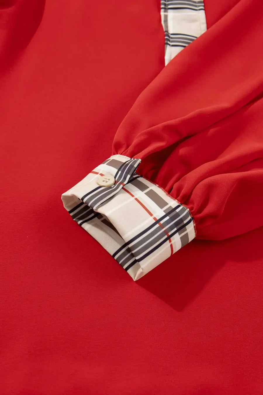 Detailed view of Red Tartan Fusion V‑Neck Blouse cuff with button and plaid pattern, showcasing quality tailoring.