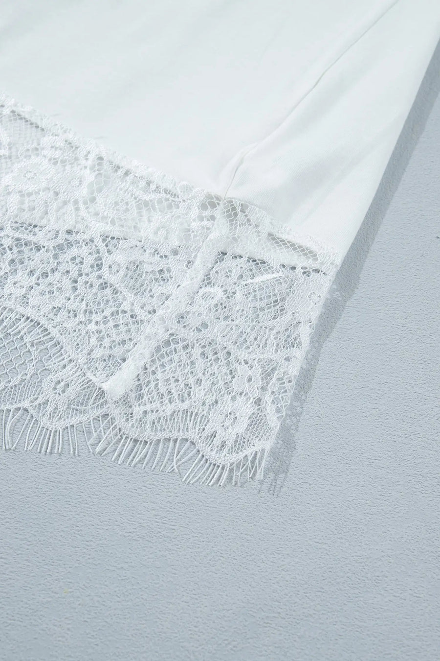 Women's asymmetric lace patchwork tee flat lay white