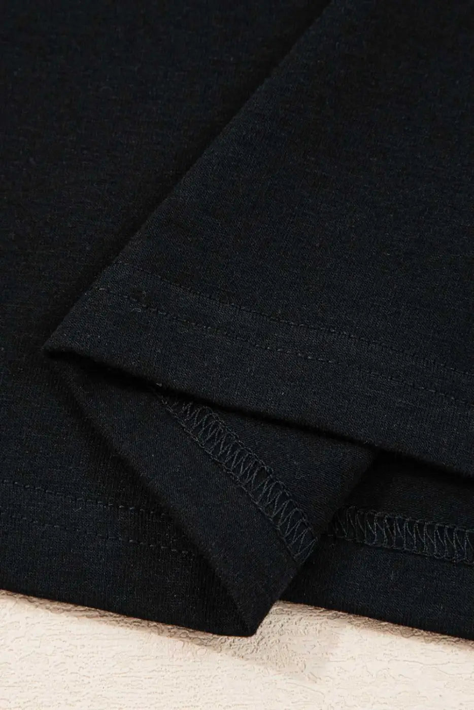 Hemline stitching detail of the Lace Sleeve Drop T-Shirt - Soft & Comfy | FashionFitz, featuring double-stitched black fabric for durability.