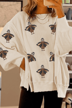 Beige sweater with turkey pattern worn by a person, blurred background
