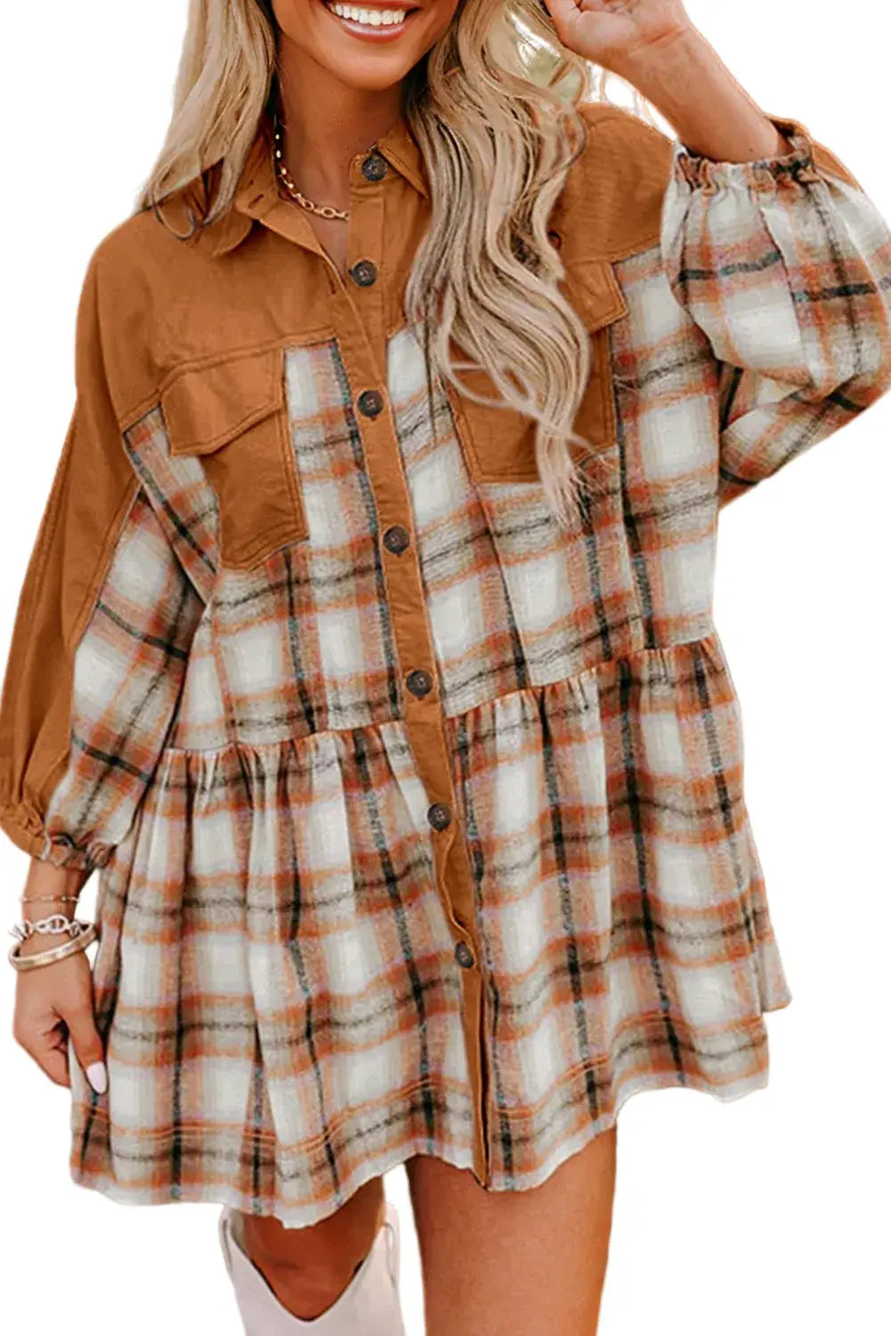 Woman wearing a plaid dress with a brown jacket outdoors