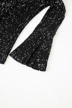 Bell sleeve detail of black sequin evening blouse, showcasing elegant flare and shimmering texture for night out looks.