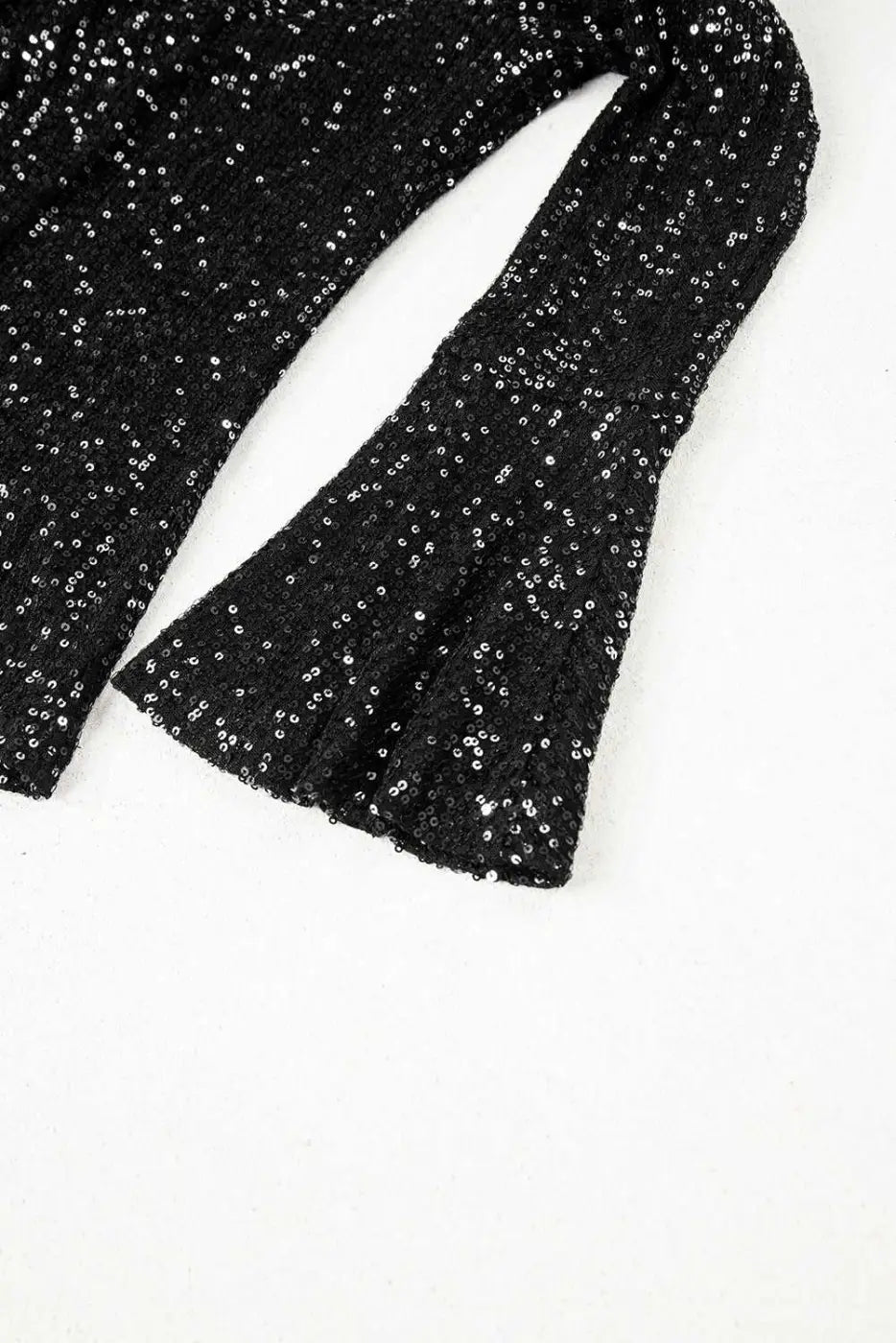 Bell sleeve detail of black sequin evening blouse, showcasing elegant flare and shimmering texture for night out looks.