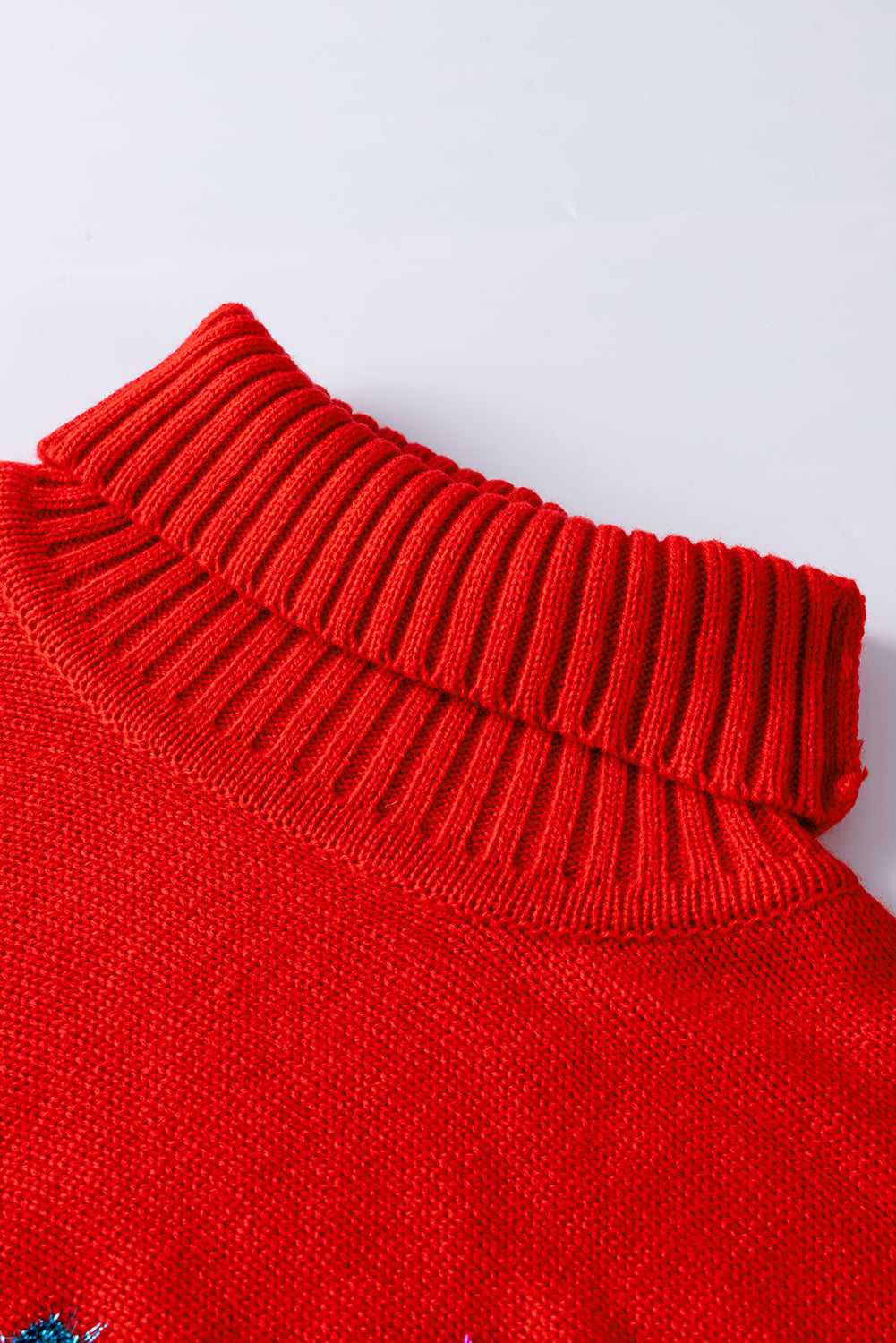 Detailed view of ribbed high neck collar on red acrylic sweater, designed for warmth and festive winter style.