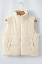 Beige corduroy puffer gilet with stand neck and zipper, displayed on hanger to highlight quilted texture and front pockets.