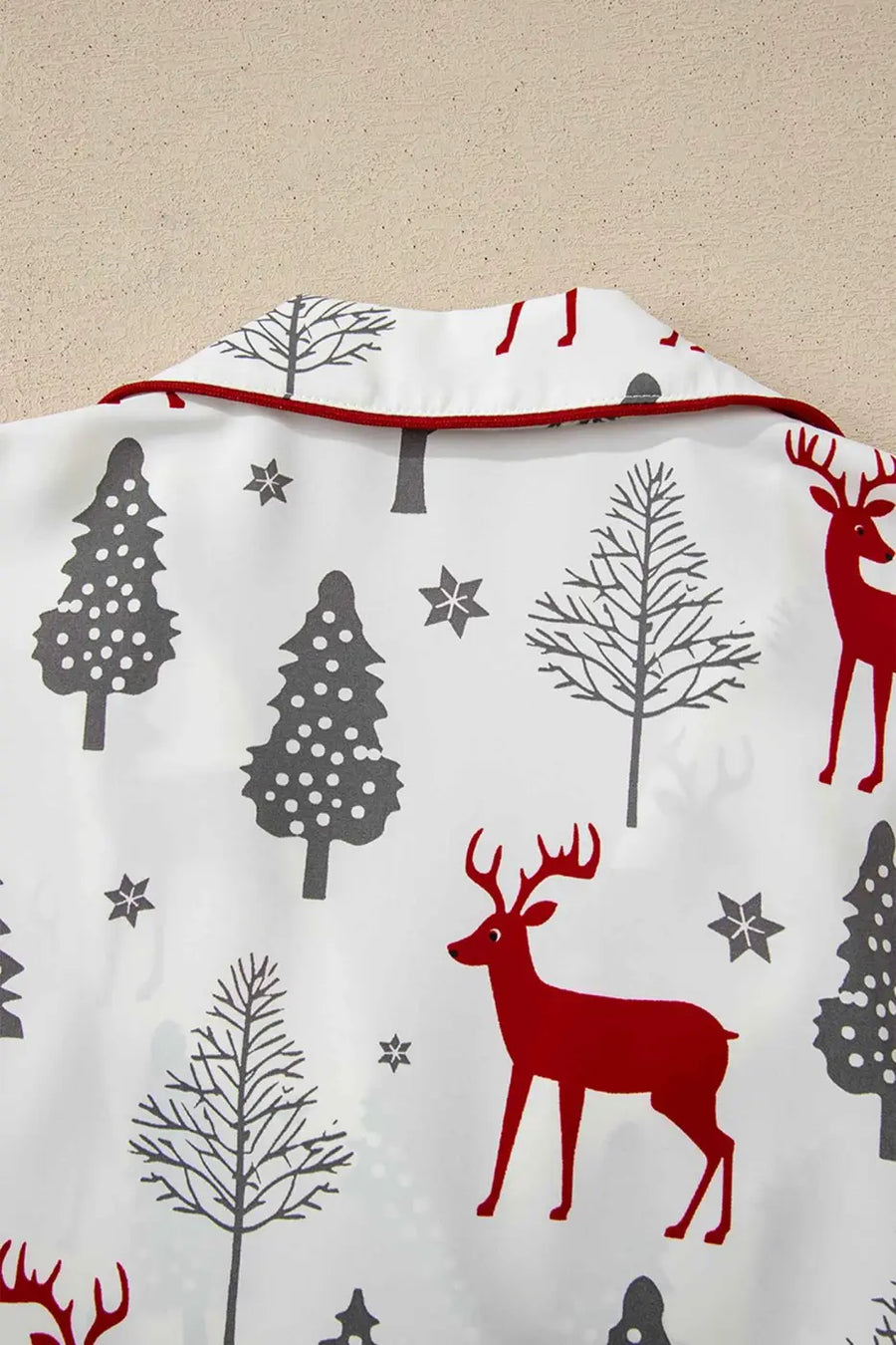 Ladies White Christmas Print Velvet Trim Pyjamas with red reindeer and grey tree motifs on soft fabric, ideal for festive loungewear comfort.