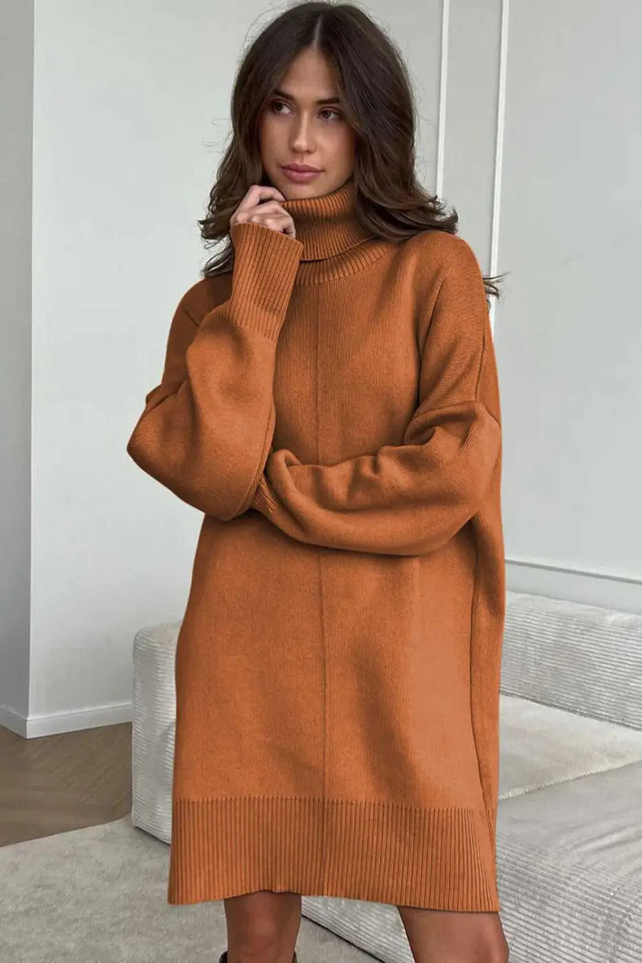 Woman wearing a brown Oversized Turtleneck Jumper Dress in a minimal indoor setting