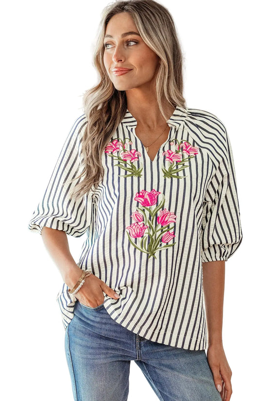Woman wearing a striped shirt with floral embroidery by a poolside.