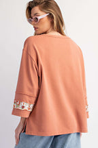 Back view of Flower Patch Graphic Top showing relaxed fit and floral patchwork on sleeves, ideal for daily spring outfits.