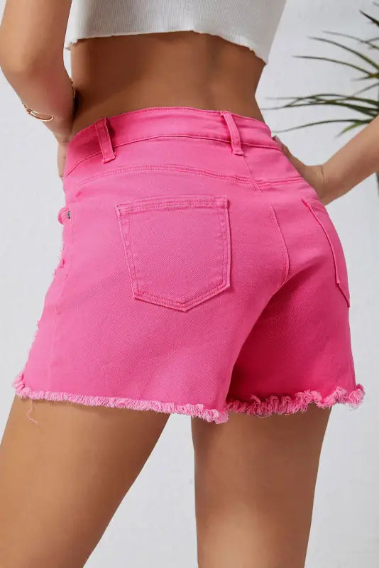 Distressed denim shorts with frayed edges in bright pink, perfect for a relax relax style