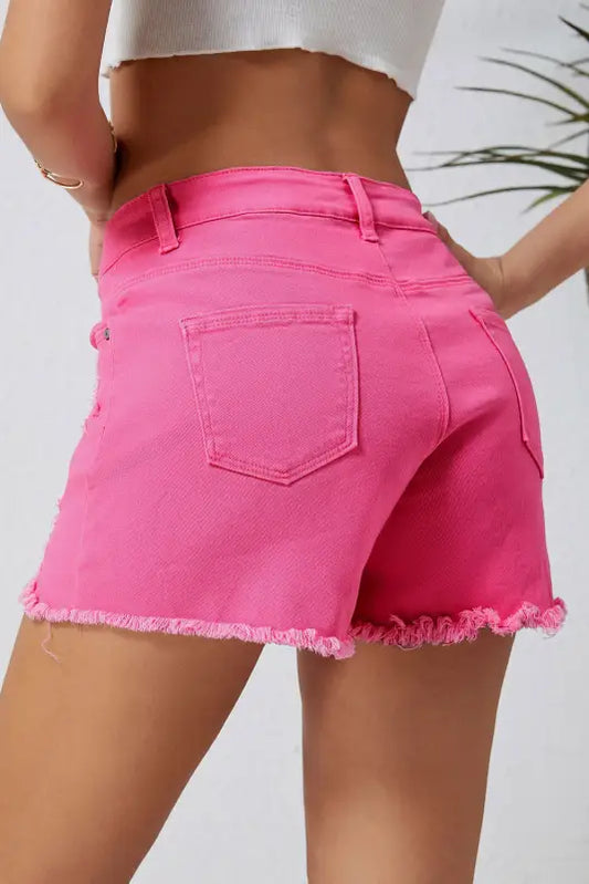 Distressed denim shorts with frayed edges in bright pink, perfect for a relax relax style