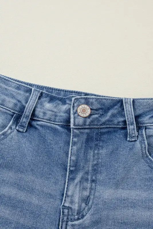 Close-up of distressed elegance wide-leg jeans waistband and top button for relaxed fit