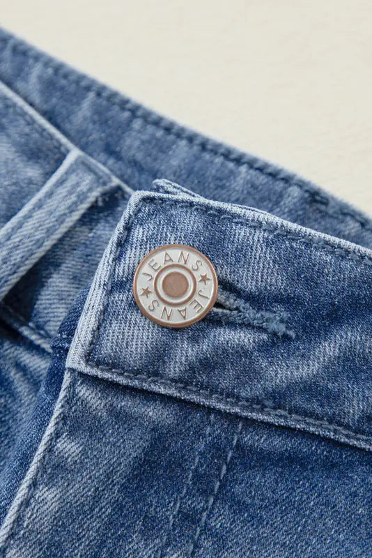 Metal button on a denim pocket of distressed elegance wide-leg jeans, engraved ’jeans’