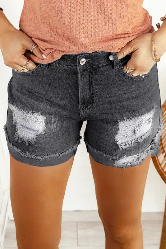 Distressed ripped denim shorts with rolled hem and thigh patches for a relaxed look