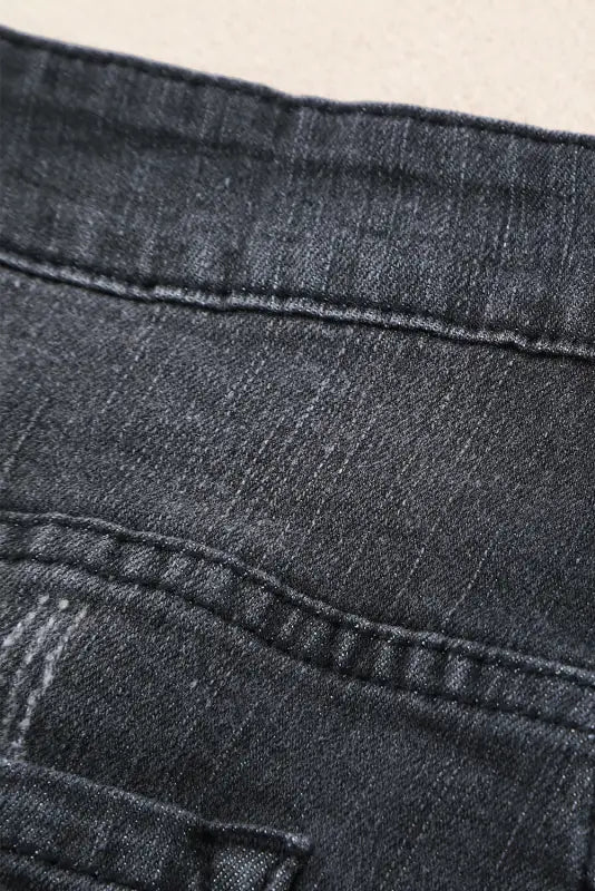 Close-up of distressed ripped denim fabric texture on rolled hem ripped denim shorts