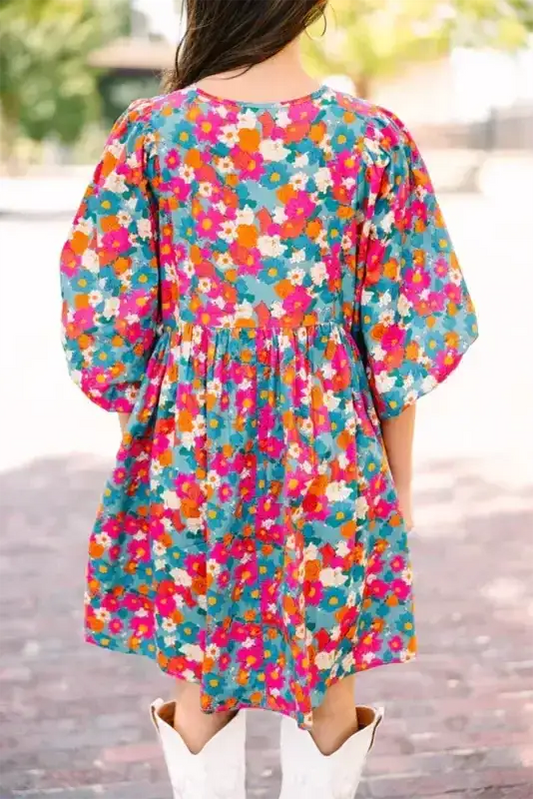 Back view of sky blue floral babydoll dress featuring multicolor print and puffed bubble sleeves in a relaxed A-line silhouette.