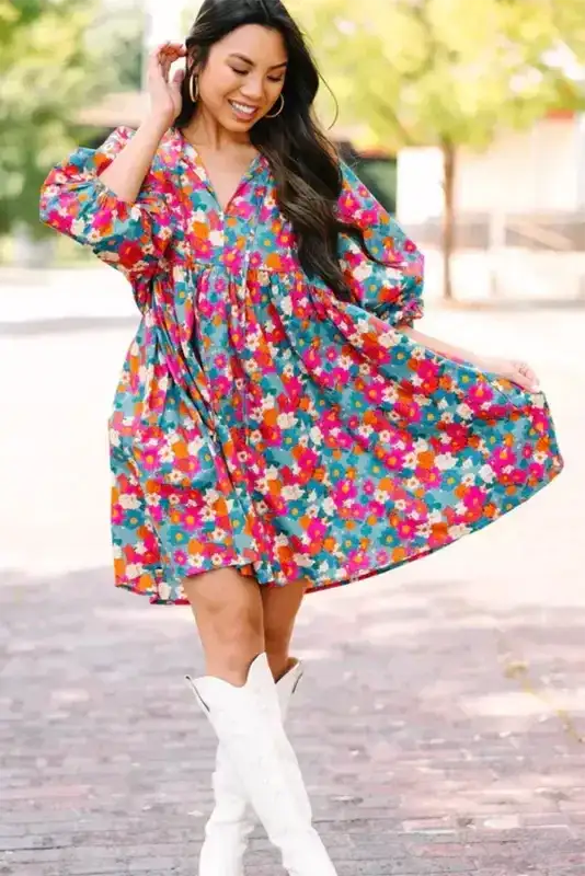Model twirling in a sky blue floral babydoll dress with bubble sleeves, showcasing its flowy A-line fit and vibrant summer print.