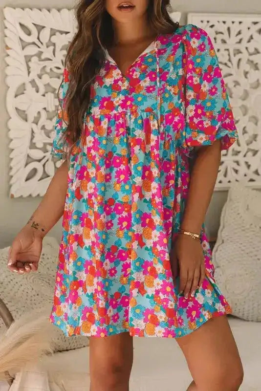 Front view of sky blue floral babydoll dress with V-neckline and puffed sleeves, styled for a feminine and casual summer look.