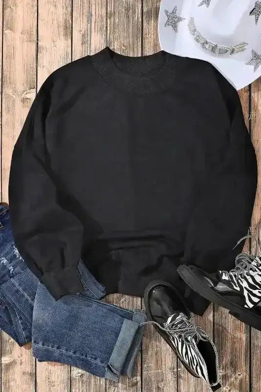 Flat lay of black Cozy Drop Shoulder Crew Neck Sweatshirt with jeans and boots, styled for a casual winter outfit inspiration.