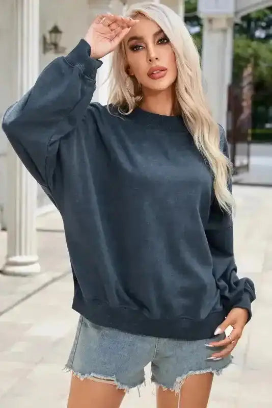 Cozy Drop Shoulder Crew Neck Sweatshirt in washed navy styled with denim shorts for a casual winter look.