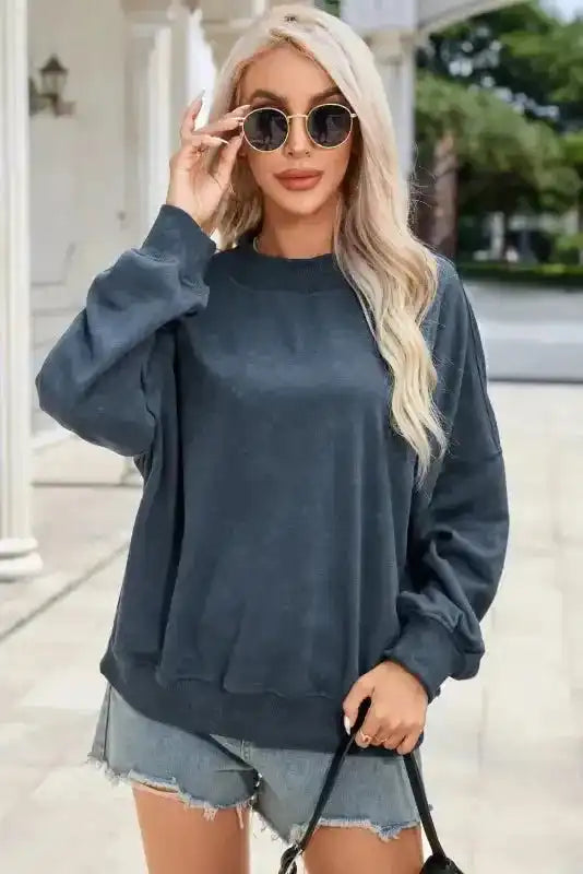 Charcoal Drop Shoulder Crew Neck Sweatshirt paired with sunglasses and shorts, offering a trendy and cozy winter look.