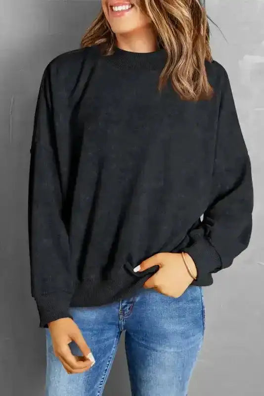 Smiling model in black Cozy Drop Shoulder Crew Neck Sweatshirt and jeans, showcasing a cozy and stylish winter wardrobe essential.
