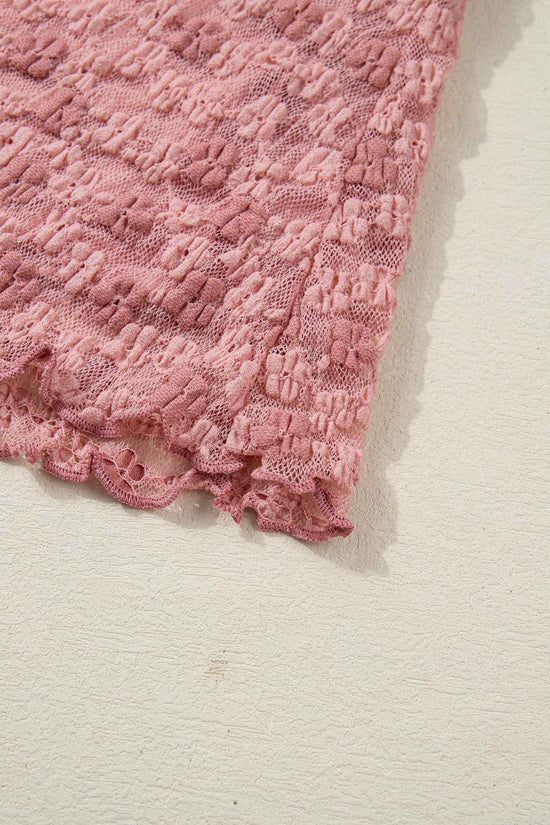 Hem detail of pink floral lace blouse showing scalloped lace edge. Delicate finish enhances romantic and feminine appeal.