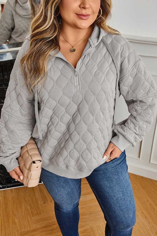 Model in curve grey quilted quarter-zip hoodie for women, featuring ribbed hem and cuffs, ideal for cosy and stylish winter layering.