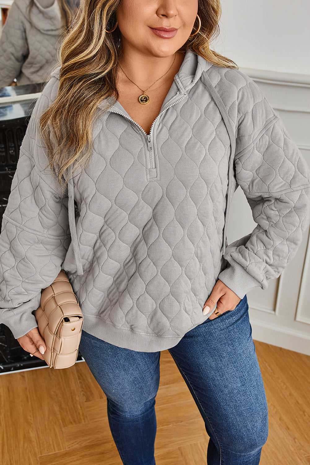 Model in curve grey quilted quarter-zip hoodie for women, featuring ribbed hem and cuffs, ideal for cosy and stylish winter layering.