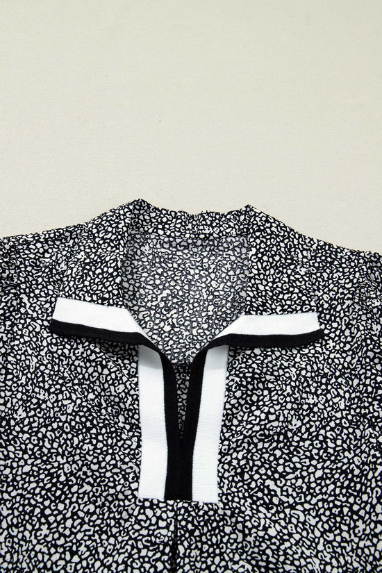 Flat lay of Black Leopard Polo Dress collar highlighting the black and white contrast trim. Bold leopard print adds a modern touch to the neckline.