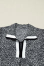 Flat lay of Black Leopard Polo Dress collar highlighting the black and white contrast trim. Bold leopard print adds a modern touch to the neckline.