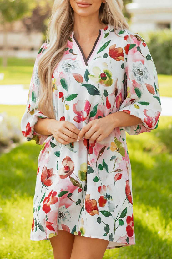 Model gently holding front of Floral Shift Dress - Casual Elegance, showcasing soft fabric and multicolor floral print.