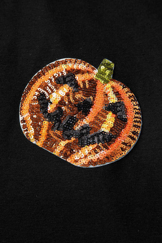 Sequined pumpkin patch with a face on a black background