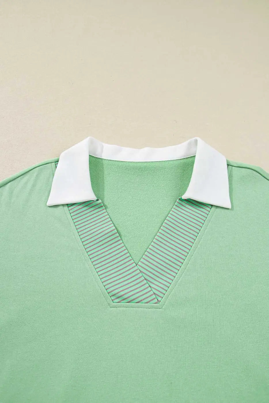 Detail shot of Curve Jade Stripe V‑Neck Sweatshirt for Women focusing on striped V-neck and white collar design.