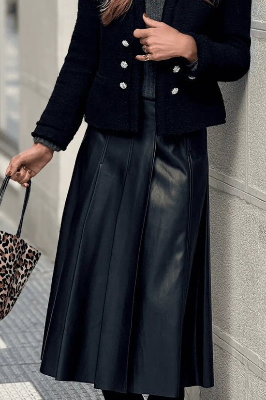 Black Faux Leather Pleated Flared Skirt | FashionFitz styled with black jacket and green top, showing elegant pleats and mid-length cut.