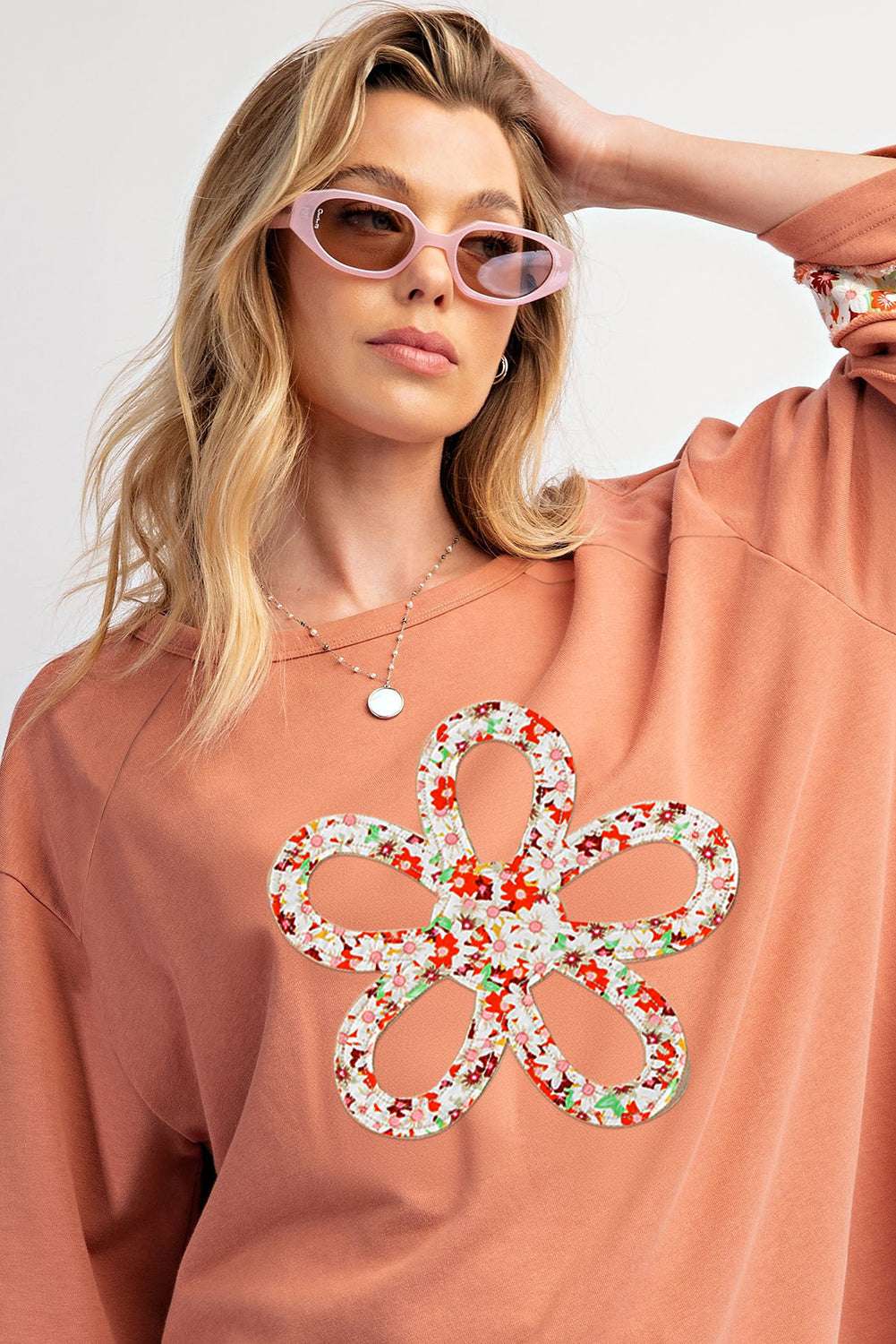 Close-up of floral applique on Flower Patch Graphic Top, highlighting the colorful patchwork and soft fabric texture.