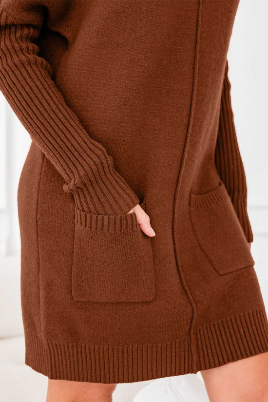 Close-up of pocket and ribbed sleeve detail on brown knit jumper dress. Cozy and stylish women’s winter sweater dress in solid color.