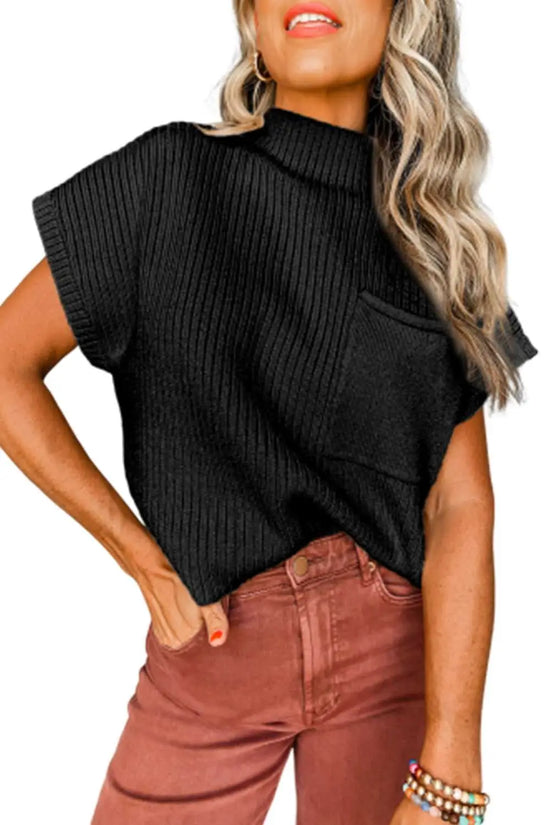 Model wearing black ribbed knit short sleeve sweater with chest pocket, styled with rust-colored pants for a trendy casual look.