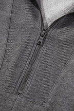 Close-up of gray zip-up sweatshirt dress zipper and ribbed collar, showcasing quality stitching and casual design.