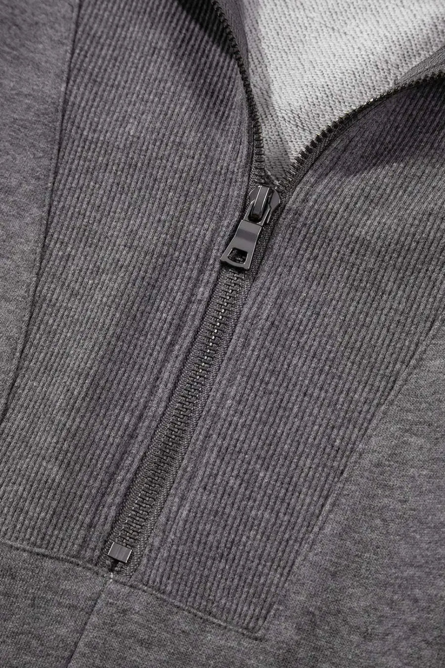 Close-up of gray zip-up sweatshirt dress zipper and ribbed collar, showcasing quality stitching and casual design.
