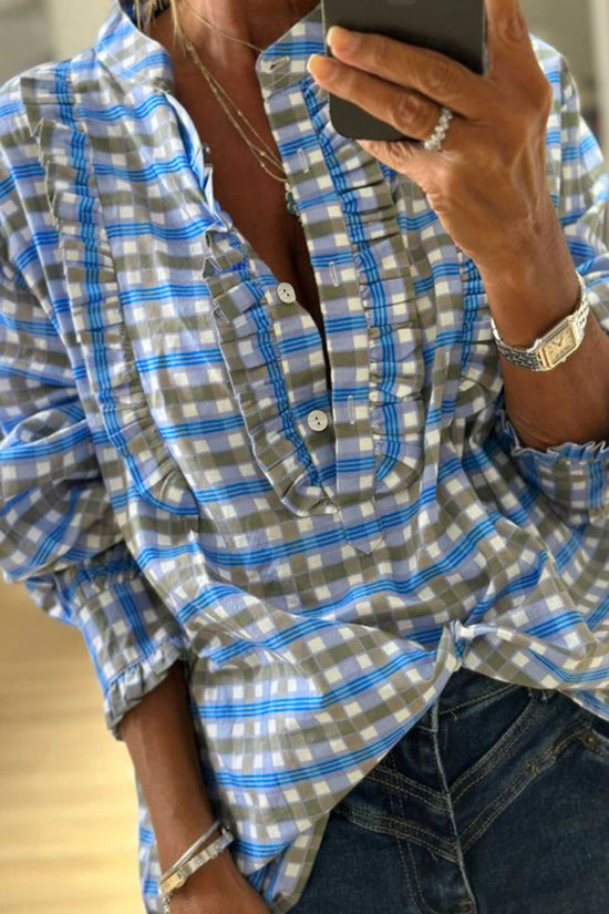 Blue plaid long sleeve frilled blouse for women in breathable cotton with half-button front, styled casually with jeans.