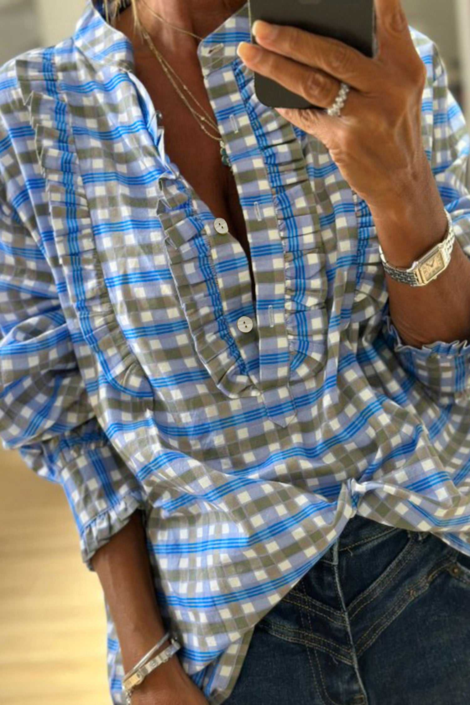 Blue plaid long sleeve frilled blouse for women in breathable cotton with half-button front, styled casually with jeans.