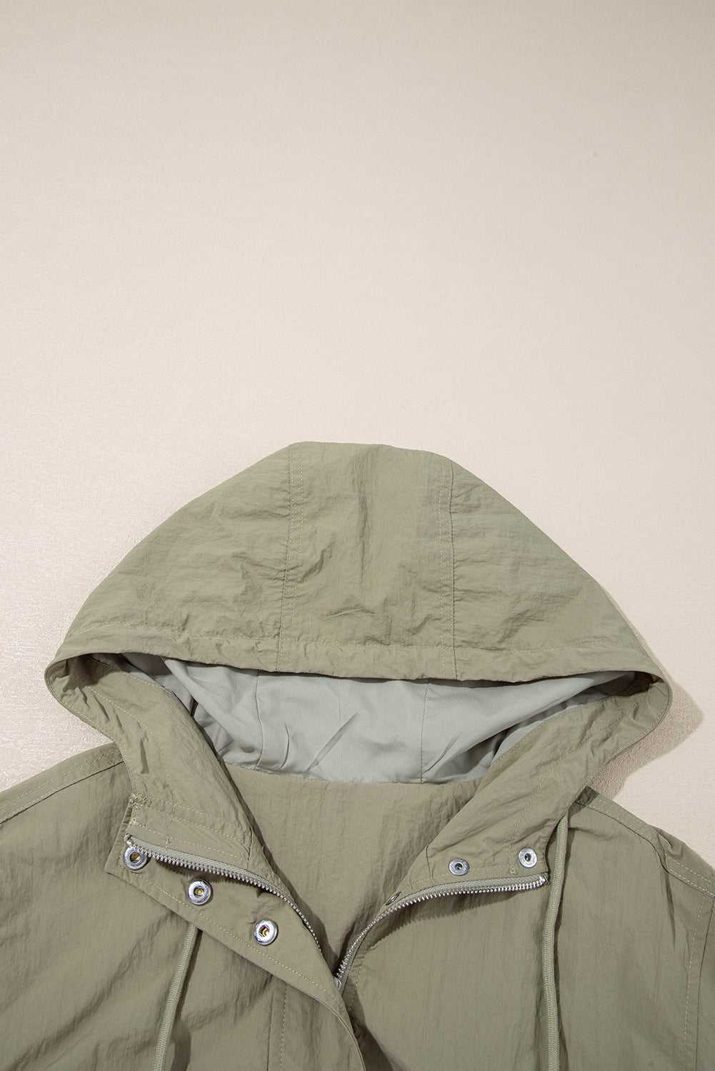 Close-up of adjustable hood on Cropped Hooded Utility Jacket in laurel green, emphasizing comfort and weather-ready design.