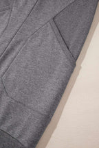 Detail of side pocket and sleeve ribbing on gray sweatshirt mini dress, emphasizing comfort and practical style.