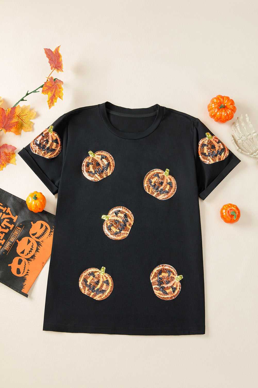 Sequin Pumpkin Face Halloween T-Shirt on a white background with decorative elements.