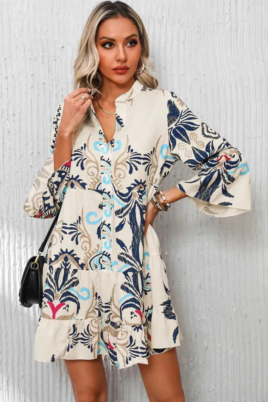 Tribal Mini Dress in beige with bold blue and red prints, styled with hoop earrings and a black shoulder bag for a casual boho outfit.