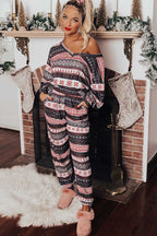 Model wearing Women's Christmas Comfort Lounge Set in Black by FashionFitz, styled with pink slippers in a holiday-themed room.