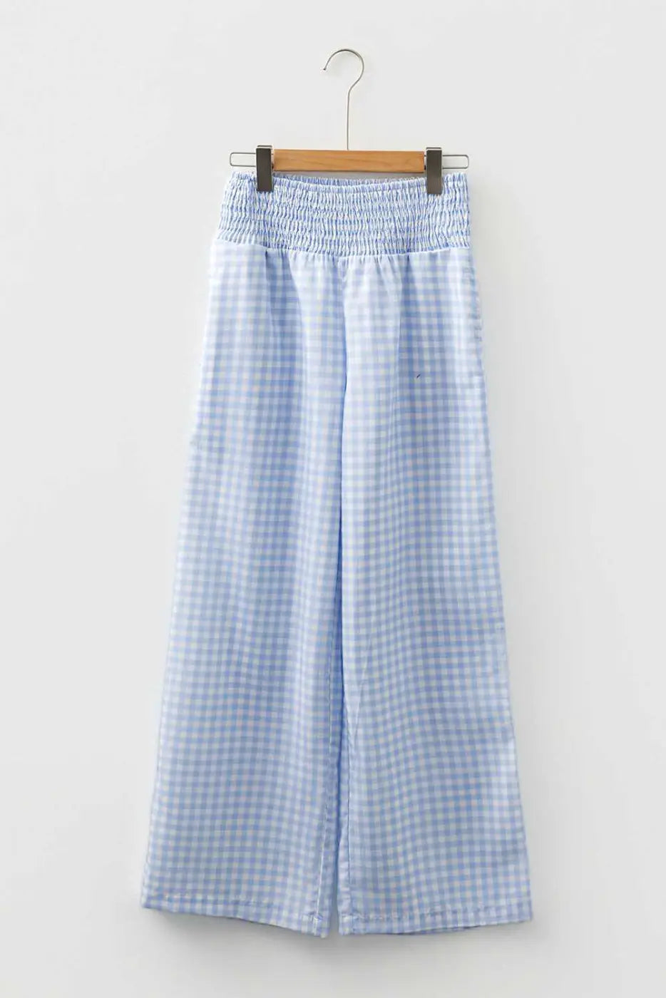 Waistband and pleat detail of plaid culotte-style trousers